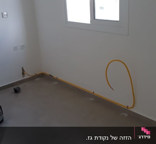 צינור גז צהוב מותקן לאורך הקיר בחדר ריק